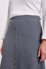 Falda midi gris de punto con botones frontales y abertura en el ruedo.