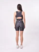 Top deportivo corto estampado con flores abstractas en tonos azul, lila y rosa. Diseño de espalda deportiva.