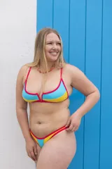 Conjunto de bikini con corpiño triangular y bombacha cavada, con ribetes en color fucsia y diseño color block en amarillo y celeste.