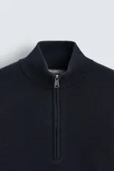 Jersey azul marino de punto, corte regular, cuello alto con cremallera, manga larga y terminaciones en rib.