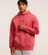 Hoodie color salmón de algodón con felpa, corte comfort, capucha con cordón ajustable, manga larga, bolsillo canguro, barras ajustadas y estampa lettering "Synthetic escape" en frente y espalda.