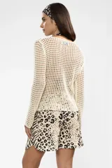 Sweater de tejido calado color crema, de manga larga y con cuello bote.