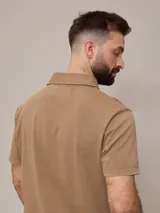 Remera polo marrón de piqué de algodón con cuello clásico y tapeta de dos botones. Logo bordado en el pecho. Corte clásico.