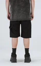 Bermuda negra de denim, corte oversize estilo carpintero con bolsillo lateral. Confeccionada en algodón con proceso de efecto desgaste.