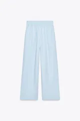 Pantalón celeste de tiro alto con cintura elástica, bolsillos delanteros y pierna ancha.