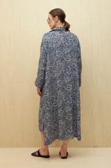 Vestido camisero midi color marrón con estampado de flores rosas, cinturón marrón y mangas largas.