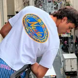 Camiseta blanca de algodón con corte oversize y estampado en la espalda con el logo de Nude Project dentro de un marco ovalado con hojas de laurel.