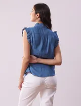 Blusa celeste de lyocell con cuello camisero, abertura con botones y volados en las sisas.