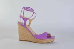 Sandalias negras de cuero con plataforma y tacón corrido de yute. Tiras finas de cuero que se atan al tobillo.