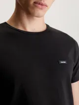 Remera negra de algodón elástico con corte slim, cuello redondo y parche con logo de Calvin Klein en el pecho.