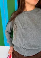 Cardigan gris de tejido de punto con cuello redondo y cierre frontal con botones.