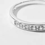 Anillo plateado con hilera de circonias engarzadas.