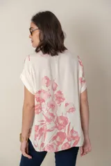 Blusa italiana de calce holgado, talle único, con cuello redondo y mangas cortas. Estampado de flores sobre fondo natural.