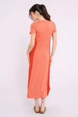 Vestido largo de tejido de punto acanalado color beige claro, con paneles laterales lisos en color marrón. Tiene mangas cortas y cuello redondo.