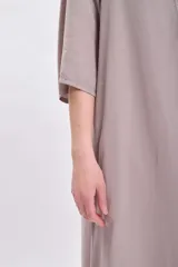 Vestido largo color visón con cuello solapado, manga corta y corte holgado.