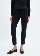 Jeans mom fit color negro con tiro alto, corte a la altura del tobillo y cinco bolsillos. Confeccionado en tejido de algodón elástico estilo tejano vaquero. Cierre de cremallera y botón.