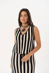 Chaleco tejido a rayas verticales en color negro y crudo, con escote en V y cierre frontal con ganchitos.