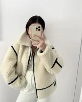 Campera de gamulan color crudo con forro interno, cierre frontal con cremallera y detalles en cuero sintético negro.