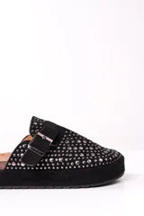 Zueco negro con plataforma, tachas plateadas y hebilla ajustable.