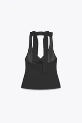 Top color rosa pálido, con cuello halter y escote en pico. Presenta un lazo en la espalda y cierre lateral con cremallera oculta.