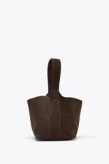 Bolso de mano tipo mini saca de cuero color marrón chocolate. Tiene asa de mano y cierre mediante clip.