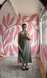 Vestido largo verde oliva con breteles finos y corte evasé. Presenta un panel lateral en color rosa.