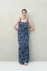 Vestido largo con estampado de hojas en tonos azules, escote recto y breteles anchos.