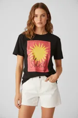 Remera negra de algodón con estampado frontal de un sol amarillo con borde rojo y texto "le Soleil".