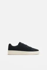 Zapatillas de hombre con cordones, fabricadas en piel serraje color azul marino. Suela plana color hueso y horma redonda.