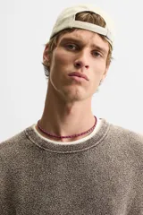 Sweater marrón de cuello redondo y manga larga, tejido con textura bouclé y efecto lavado.