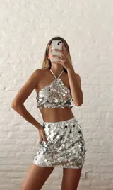 Top plateado con lentejuelas, de corte halter y espalda descubierta.