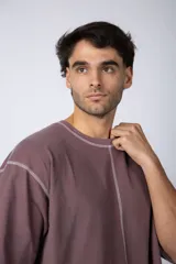 Remera negra oversize con mangas cortas y costuras a la vista en color blanco.