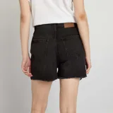 Short de jean gris desgastado, con corte alto y detalles rasgados en el dobladillo.