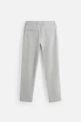 Pantalón negro de corte slim fit, confeccionado en tejido elástico. Cuenta con cintura elástica, bolsillos frontales y traseros de vivo. Cierre frontal con cremallera y botón.