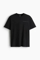 Remera negra de algodón con cuello redondo ribeteado acanalado, hombros caídos, diseño estampado con texto "New York, NY 11201" y bajo recto.