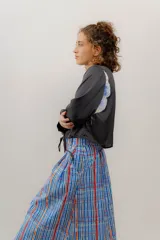 Camisa crop negra con estampado de una flor y un insecto, con cintas para atar en la cintura.