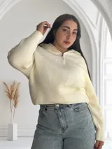 Sweater de punto color crudo con cuello polo y cierre metálico.