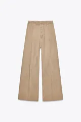 Pantalón de jean color beige, de tiro alto, corte wide leg y largo al tobillo.