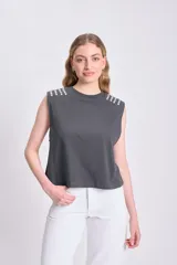 Remera musculosa gris claro con cuello redondo y apliques de strass en los hombros.