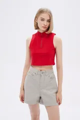 Top rojo de algodón con cuello alto, cierre frontal con cremallera y diseño sin mangas.
