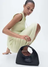 Vestido midi color amarillo pálido, de corte recto y sin mangas, con cuello redondo y efecto arrugado.