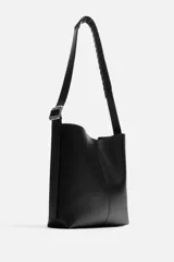 Bolso tipo shopper color negro, con compartimento principal con cierre mediante imán y bolsillo plano interior. Asa de hombro ajustable.