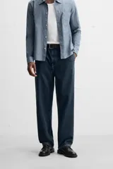 Pantalón de jean azul oscuro, corte recto, confeccionado en denim de algodón y lyocell. Cuenta con bolsillos frontales y traseros de vivo. Cierre frontal con cremallera y botón.