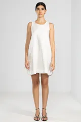 Vestido corto blanco de lino italiano con fibra metalizada, corte holgado y sisas amplias. Presenta cortes redondeados a los costados y la insignia de tigre Polonio en la espalda.