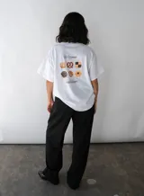 Remera blanca de manga corta con estampa de galletas en la espalda y logo de la marca en el frente.