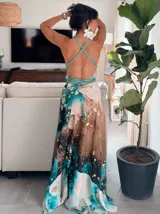 Vestido largo de tela fluida, color verde esmeralda con estampado abstracto en tonos turquesa y detalles dorados. Diseño asimétrico con un solo tirante tejido en el hombro.