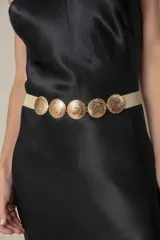 Cinto elástico dorado con cinco hebillas circulares metálicas con diseño floral.