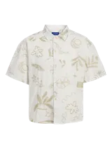 Camisa blanca de algodón con estampado de motivos florales y geométricos en color beige, cuello resort, mangas cortas, cierre frontal con botones y corte amplio.