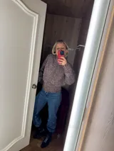 Cardigan de punto grueso color gris jaspeado, con cuello alto y mangas largas.