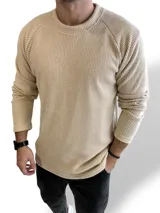 Buzo de hilo en color beige, de corte relajado y manga larga con textura acanalada.